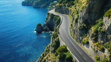 A luxury sports car parked overlooking a sparkling blue Mediterranean coastline